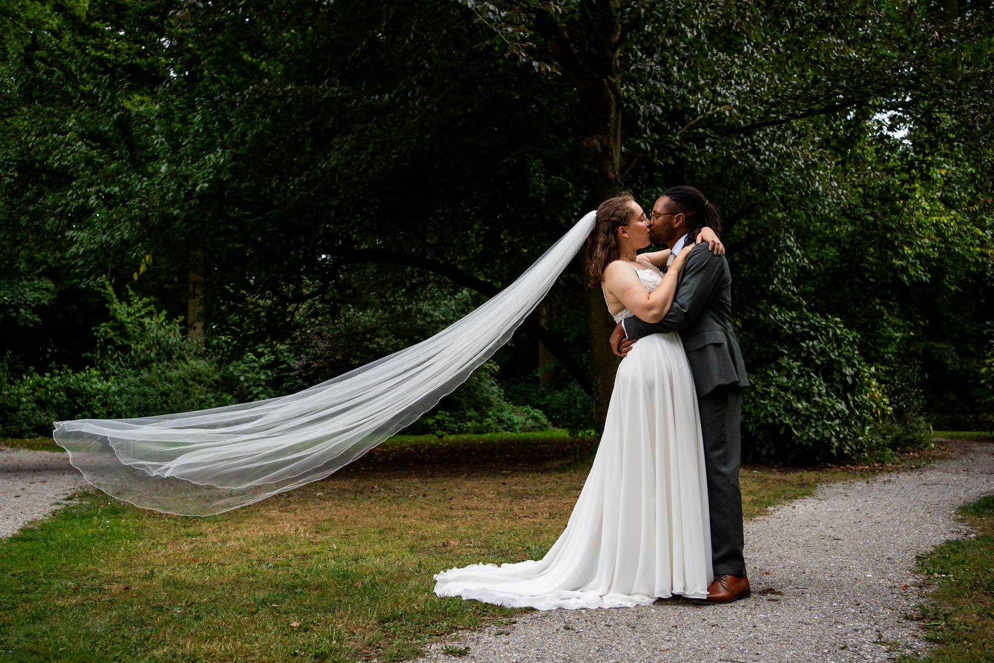 Bruidspaar tijdens de fotoshoot met een waaiende sluier