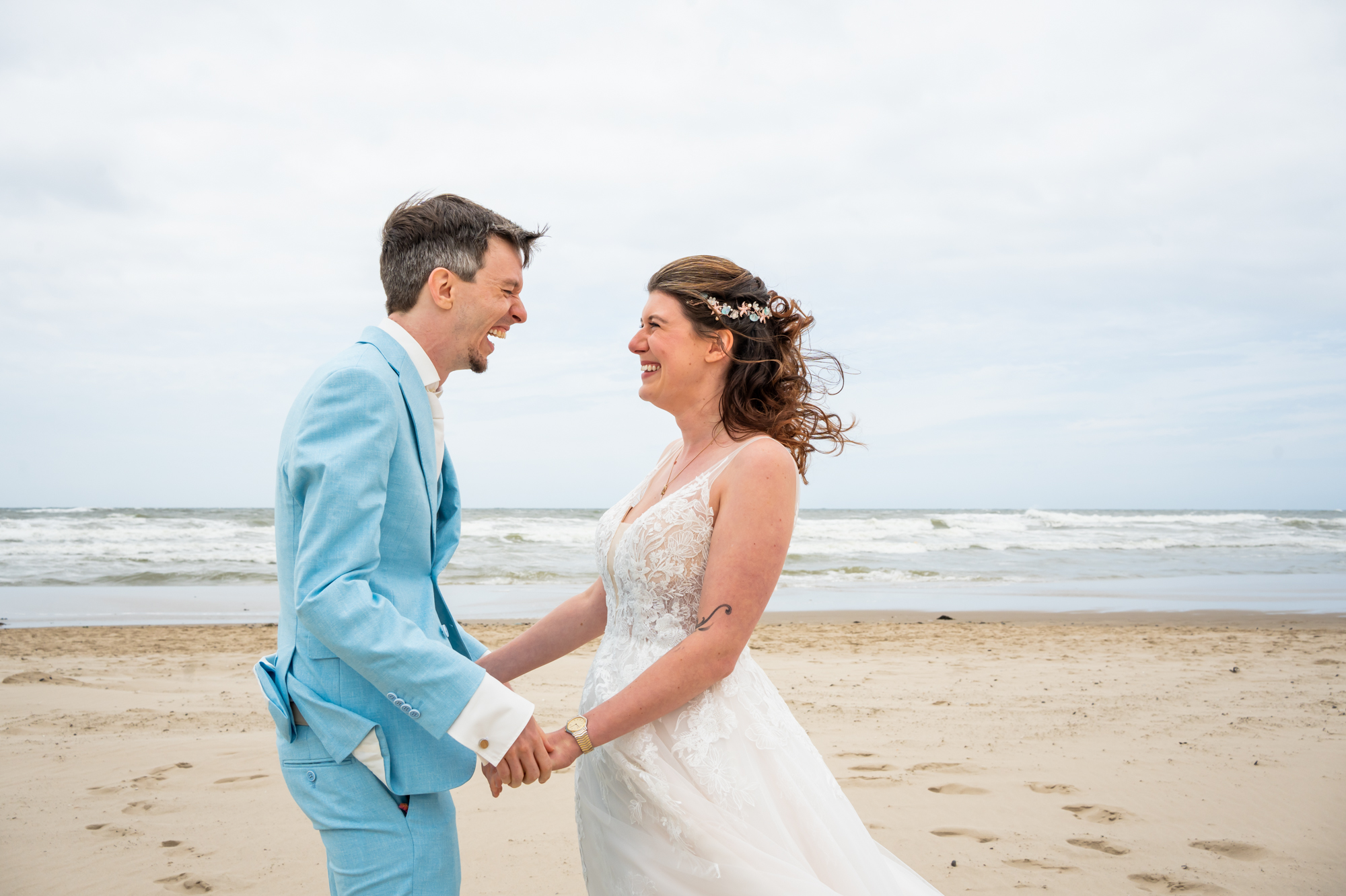 Het firstlook moment van het bruidspaar op het strand