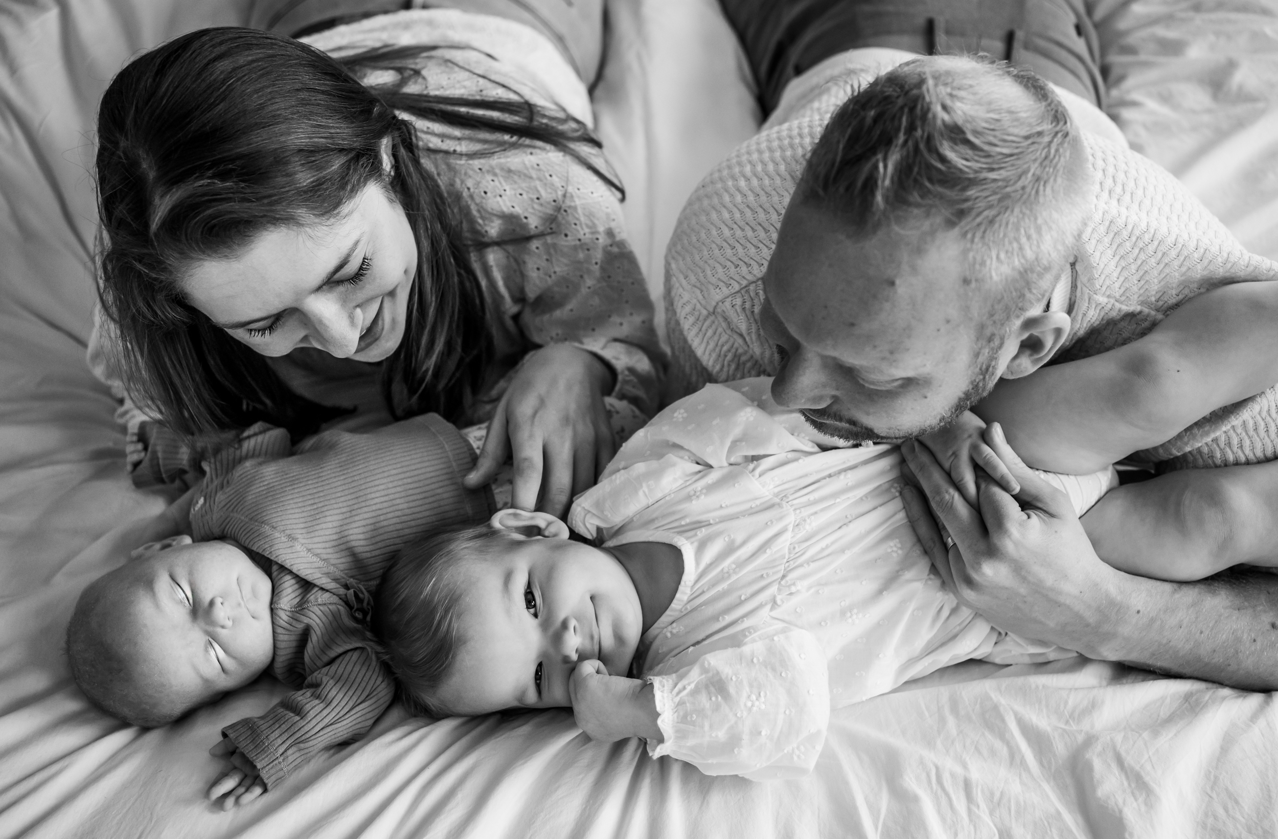 Heerlijk knus op het bed. Een gezellige gezinsfoto tijdens een baby shoot