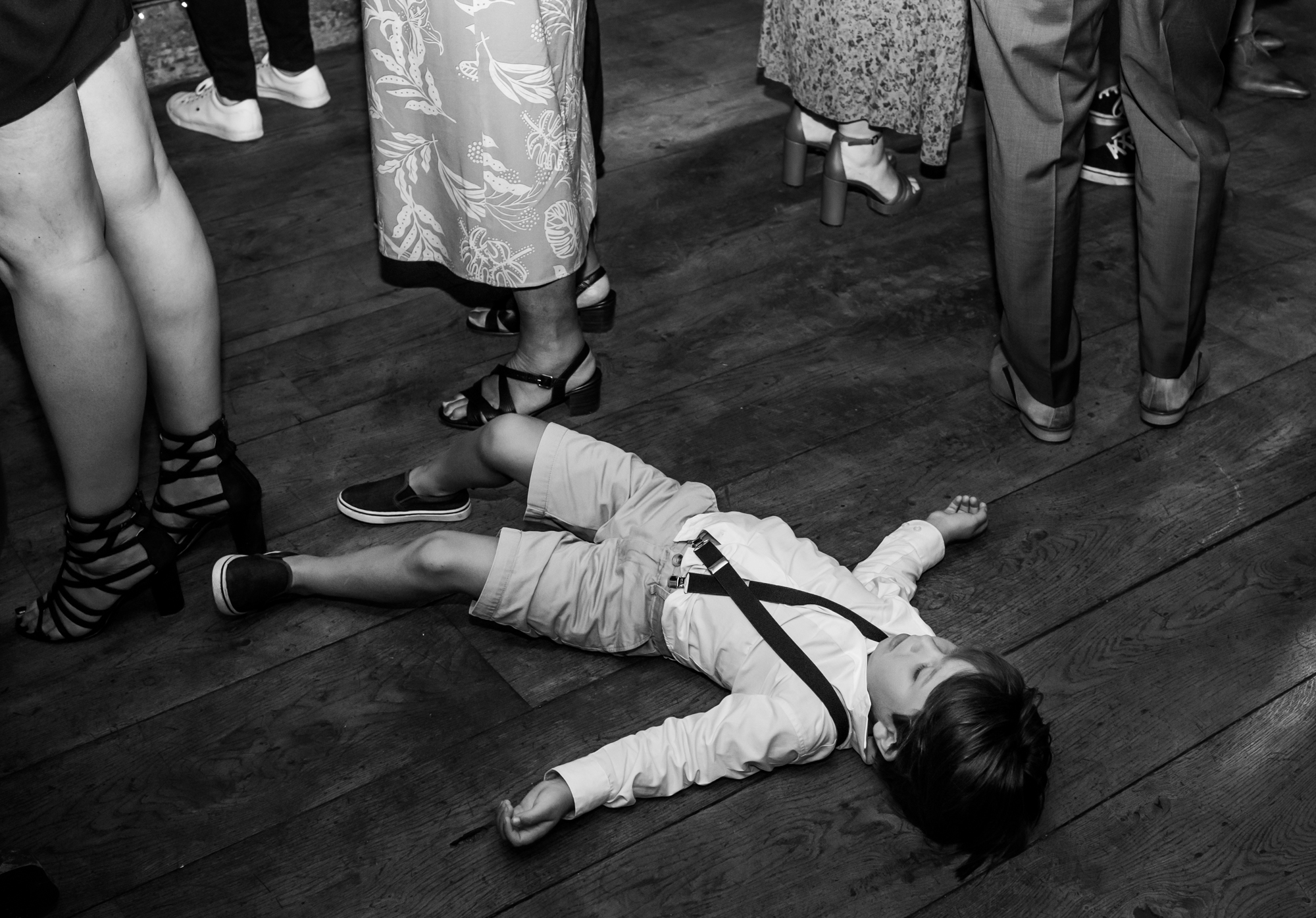 Kindje is moe tijdens het trouwfeest en gaat slapen op de grond