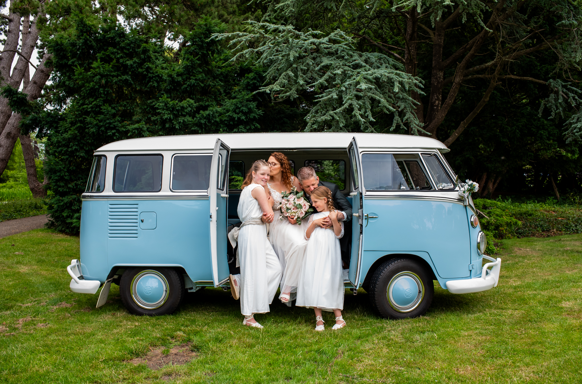 bruidspaar op de foto met de trouwauto