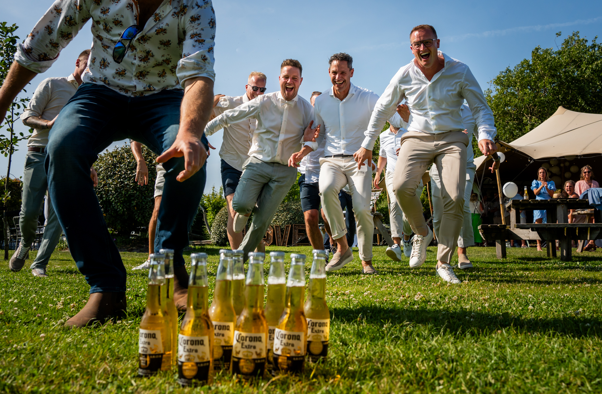 De bruidegom en zijn vrienden doen een wedstrijdje wie het eerst het biertje kan bemachtigen 